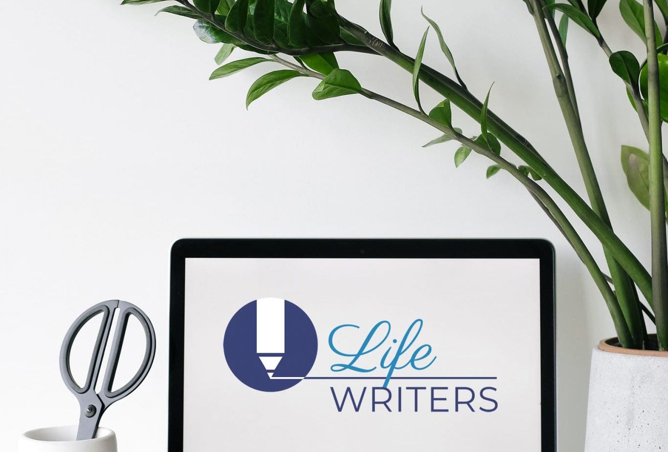 laptop with Life Writers logo and plant
