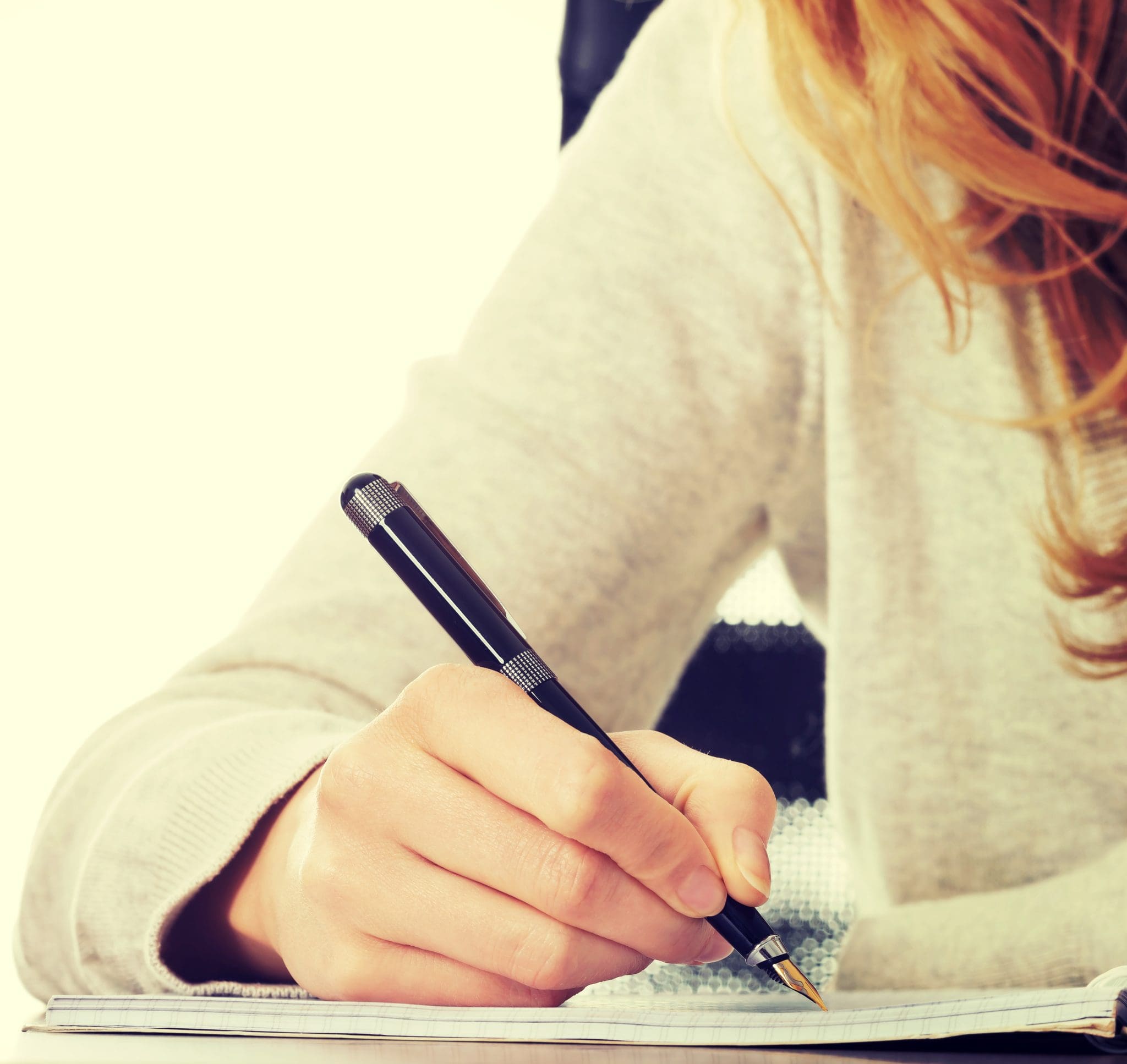 Handwriting, hand writes with a pen in a notebook